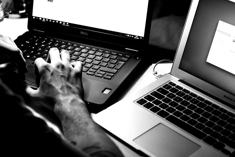 Hands typing on a laptop keyboard