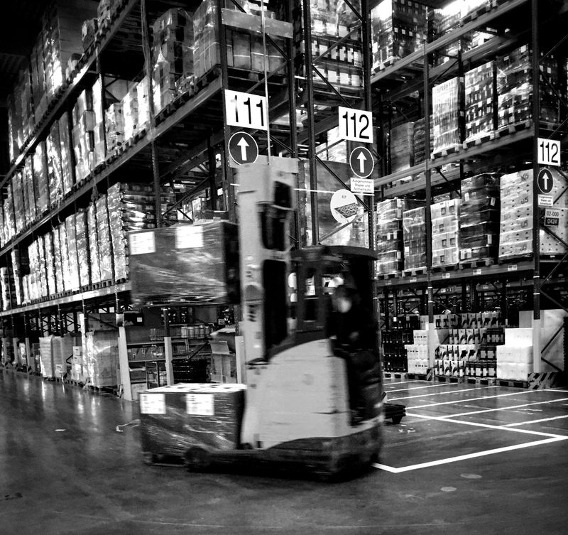 Forklift in a warehouse between racks
